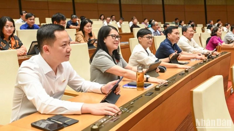Các đại biểu Quốc hội biểu quyết thông qua Nghị quyết của Quốc hội về thí điểm về một số cơ chế, chính sách đặc thù phát triển nhà ở xã hội. (Ảnh: BÙI GIANG)