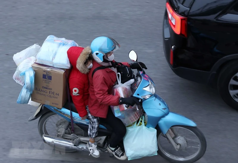 Dễ dàng bắt gặp chiếc xe máy chở cồng kềnh đồ đạc trên đường. (Ảnh: Hoàng Hiếu/TTXVN)