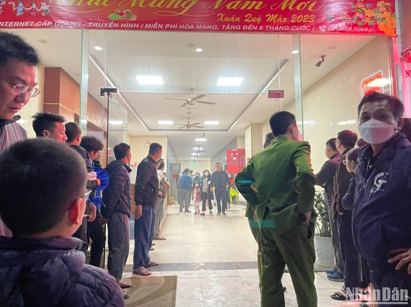 Cảnh sát hướng dẫn người dân thoát xuống sân chung cư trong đêm. (Ảnh: Đ.N)