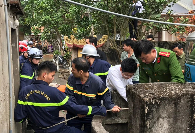 Cảnh sát Phòng cháy chữa cháy và Cứu hộ cứu nạn tiến hành đưa nạn nhân ra khỏi giếng nước. (Ảnh: Công an Ba Vì)
