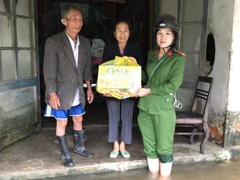 Thượng úy Phan Thị Thủy trao quà cho người dân xã Thạch Hội trong đợt lũ lịch sử năm 2020. (Ảnh: Nhân vật cung cấp)