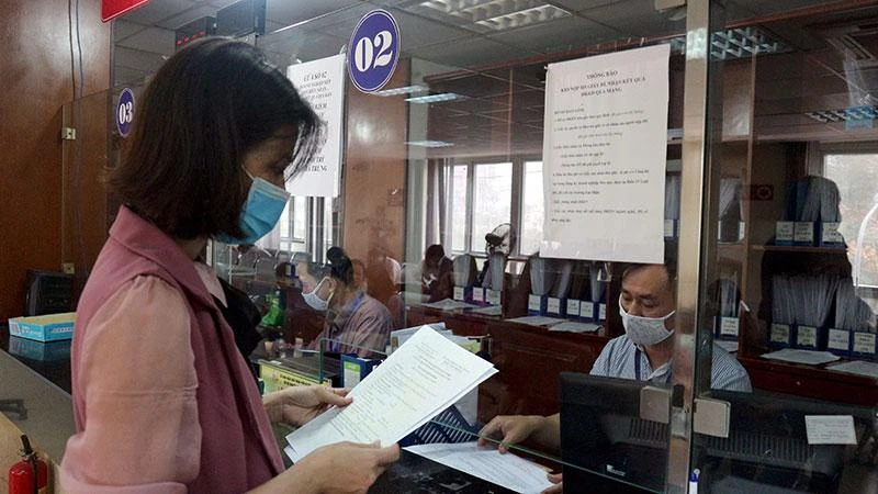 Doanh nghiệp làm thủ tục đăng ký kinh doanh tại Bộ phận một cửa Sở Kế hoạch và Đầu tư Hà Nội. (Ảnh: Mạnh Khánh)