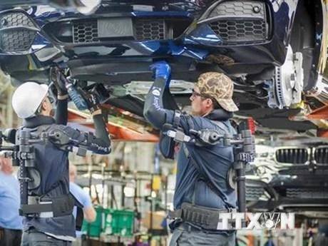 Công nhân làm việc trên dây chuyền sản xuất xe ô tô của Hãng BMW (Đức). (Ảnh: DW/TTXVN)