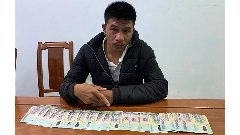Đối tượng Đoàn Văn Dương với số tiền giả mà cơ quan chức năng thu giữ. (Ảnh: Công an cung cấp)