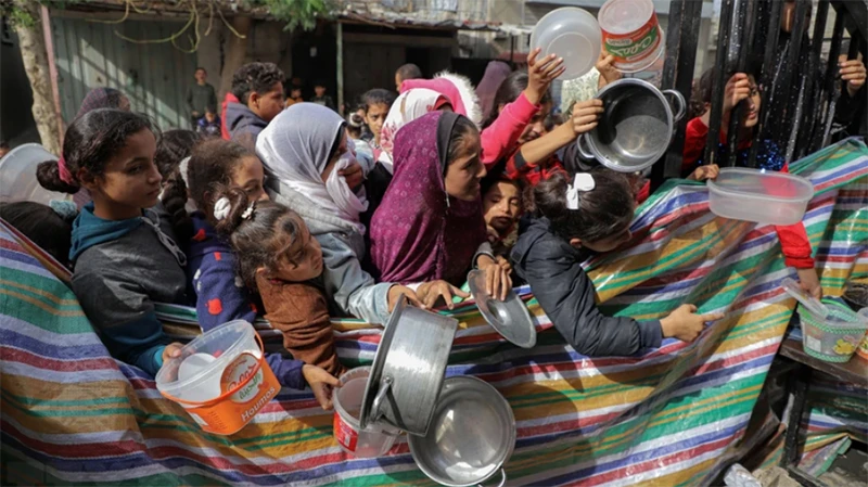 Người dân chờ được phát thực phẩm cứu trợ tại Rafah, Dải Gaza. (Ảnh: THX/TTXVN)