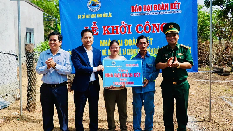 Nhà báo Trương Thành Trung, Tổng Biên tập Báo Đại Đoàn Kết cùng Đại tá Rơ Lan Ngân, Phó Chính ủy, Bộ đội Biên phòng tỉnh Đắk Lắk; lãnh đạo xã Krông Na trao bảng tượng trưng cho gia đình ông Y Hớn Niê. (Ảnh: THANH NGA)