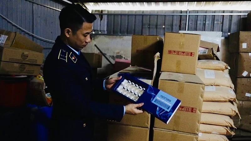 Lực lượng quản lý thị trường kiểm tra hàng hóa giả nhãn hiệu tại hộ kinh doanh N.V.T. trên địa bàn huyện Chương Mỹ (Hà Nội).