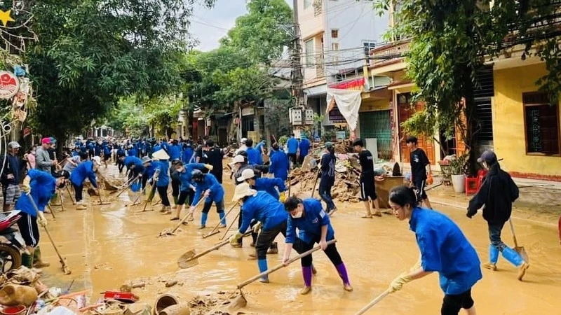 Thanh niên tình nguyện Yên Bái tham gia vệ sinh môi trường tại thành phố Yên Bái sau khi báo chão số 3 đi qua. (Ảnh: THANH SƠN)