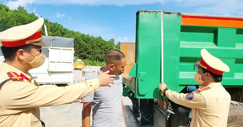 Lực lượng Cảnh sát giao thông Công an tỉnh Quảng Ninh xử phạt vi phạm và yêu cầu chủ phương tiện cắt bỏ thành thùng xe cơi nới không đúng quy định.