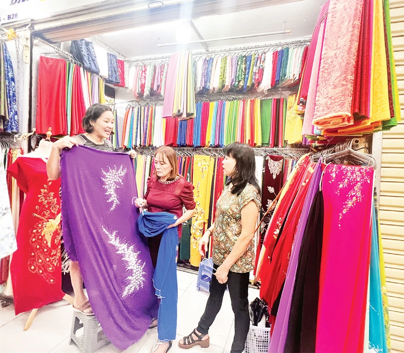 Khách tìm mua vải tại một sạp hàng ở Trung tâm thương mại-dịch vụ An Đông.
