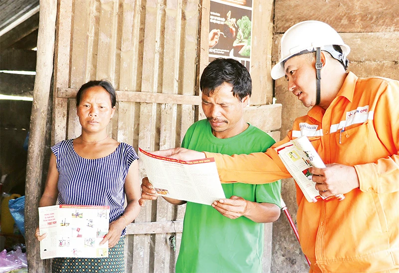 Công nhân Điện lực Quảng Bình tuyên truyền, hướng dẫn đồng bào A Rem sử dụng điện lưới an toàn.