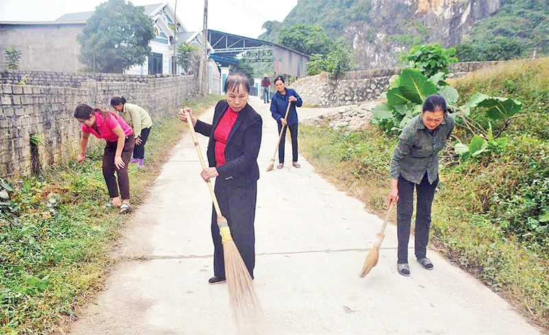 Bà Hoàng Thị Phượng cùng người dân trong thôn quét dọn, vệ sinh đường giao thông nông thôn.