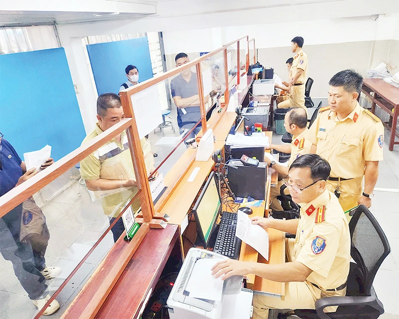 Cán bộ Cảnh sát giao thông hướng dẫn người dân, doanh nghiệp thực hiện thủ tục cấp đổi giấy phép lái xe.