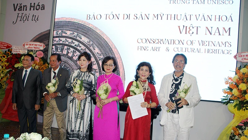 Ông Phạm Hoàng Thịnh (bìa trái), Trưởng Văn phòng đại diện Liên Hiệp các Hội UNESCO Việt Nam tại Thành phố Hồ Chí Minh trao quyết định và chúc mừng Ban Giám đốc Trung tâm.