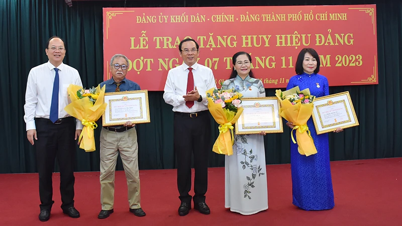 Đồng chí Nguyễn Văn Nên, Ủy viên Bộ Chính trị, Bí thư Thành ủy Thành phố Hồ Chí Minh và đồng chí Nguyễn Hồ Hải, Phó Bí thư Thành ủy chúc mừng đảng viên được nhận Huy hiệu Đảng.