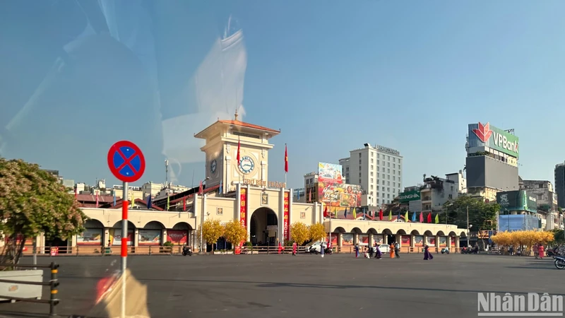 Người dân chụp hình, tham quan trước cổng chợ Bến Thành (quận 1) sau kỳ nghỉ Tết. Ảnh: MINH CHÁNH