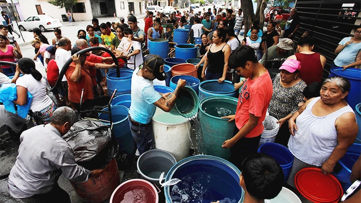 Người dân xếp hàng chờ lấy nước. Ảnh: AP