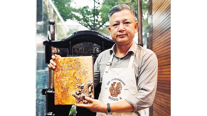 Họa sĩ Trần Đại Thắng với cuốn “Lịch sử Việt Nam bằng hình” do Đông A phối hợp NXB Đại học Sư phạm ấn hành.