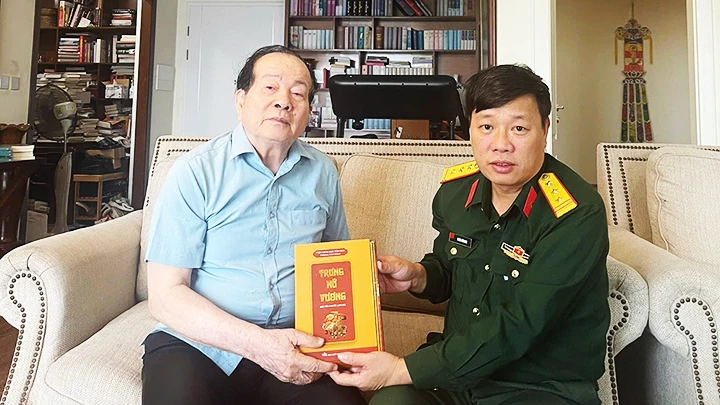 Nhà văn Phùng Văn Khai (phải) tặng nhà thơ Hữu Thỉnh cuốn tiểu thuyết mới “Trưng nữ vương”.
