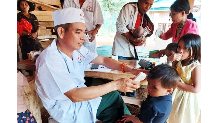 Thiếu tá quân nhân chuyên nghiệp Trần Minh Vũ, y sĩ quân y Đồn Biên phòng A Vao) khám, chữa bệnh cho bà con Pa Ling.