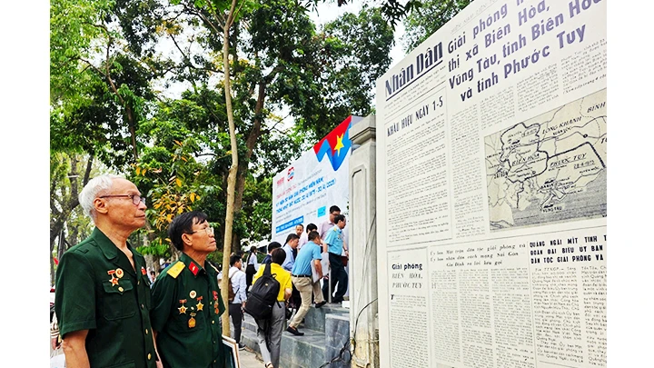 Hạ sĩ Lữ Văn Hỏa (bên trái) bồi hồi khi sống lại một thời hào hùng tại không gian triển lãm.