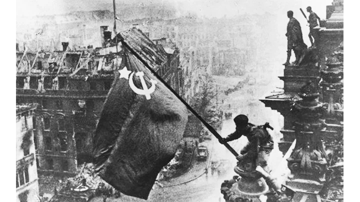 Một chiến sĩ Hồng quân Liên Xô phất cờ mừng chiến thắng tại Berlin. Ảnh tư liệu