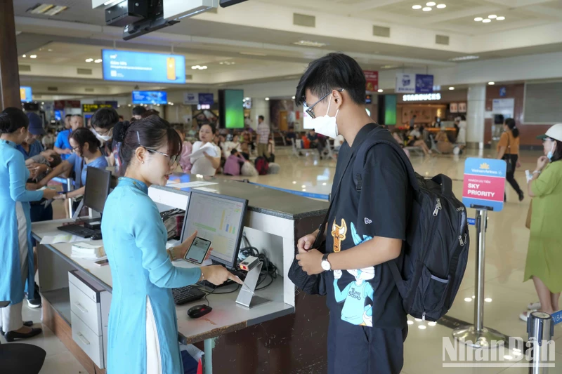 Hành khách sử dụng VNEID tại cửa ra tàu bay. (Ảnh: SƠN BÁCH)