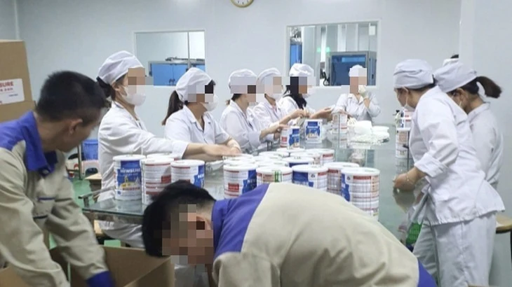 Công nhân đóng hộp thành phẩm tại cơ sở sản xuất sữa bột giả quy mô lớn vừa bị Công an thành phố Hà Nội triệt phá. (Ảnh: Báo Công an nhân dân)