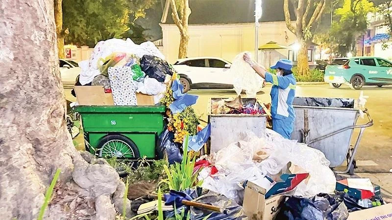 Công nhân Công ty Môi trường đô thị Hà Nội thu gom rác thải trên phố. (Ảnh: nhandan.vn)