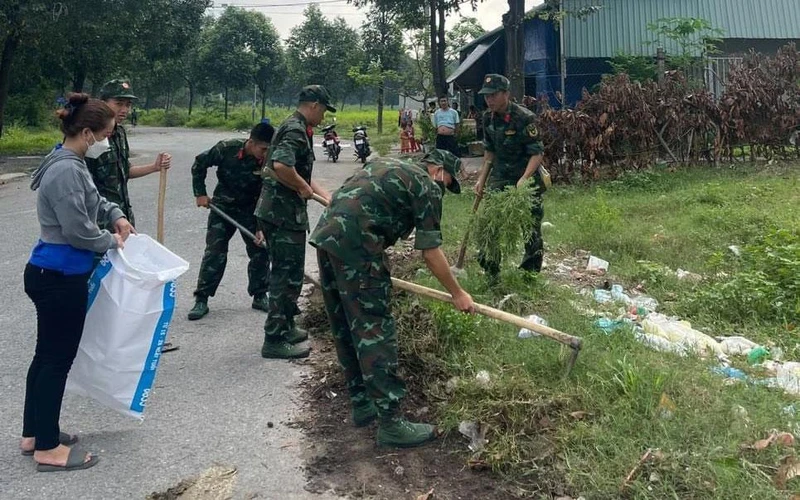 Bộ đội giúp dân tổng vệ sinh môi trường để phòng, chống dịch sốt xuất huyết ở Bình Dương. 