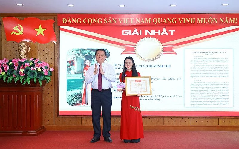 Đồng chí Nguyễn Trọng Nghĩa trao giải nhất Cuộc thi tặng thí sinh Nguyễn Thị Minh Thu. 
