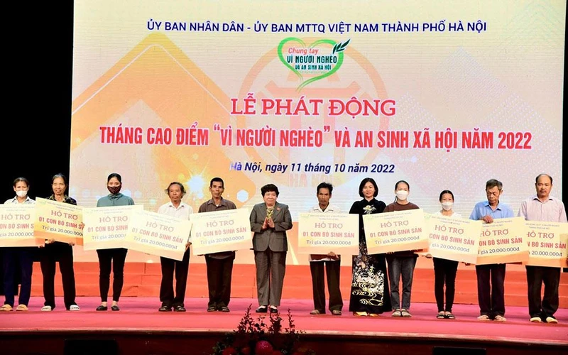 Trao trao kinh phí hỗ trợ xây nhà đại đoàn kết và phương tiện, công cụ sản xuất tặng các hộ nghèo. (Ảnh: Viết Thành)