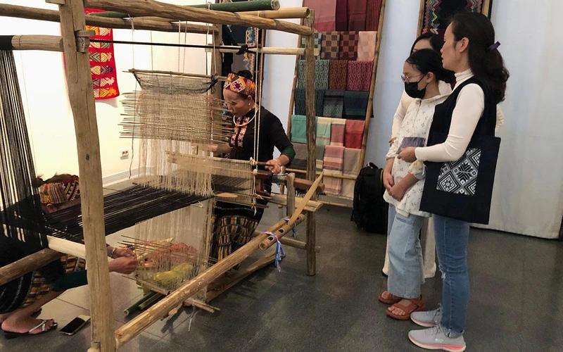 Khách tham quan triển lãm thích thú với phần trình diễn nghề dệt của nghệ nhân dân tộc Thái Thanh.