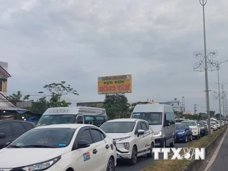 Xe ôtô nối đuôi nhau, nhích từng chút một qua cầu Rạch Miễu. (Ảnh: TTXVN)
