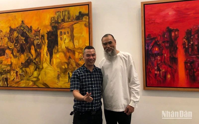 Họa sĩ Hoàng Định tại triển lãm.