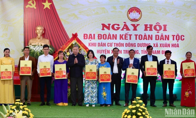 Đại tướng Tô Lâm và Bí thư Tỉnh ủy Nam Định Phạm Gia Túc tặng quà cho bà con thôn Đông Dương, xã Xuân Hòa, huyện Xuân Trường trong Ngày hội Đại đoàn kết toàn dân tộc tại địa phương.