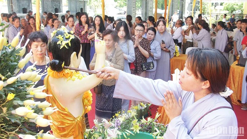 Chư Tăng, Phật tử và bà con kiều bào thực hiện các nghi lễ Tắc Bạt và tắm Phật. (Ảnh: HẢI TIẾN)