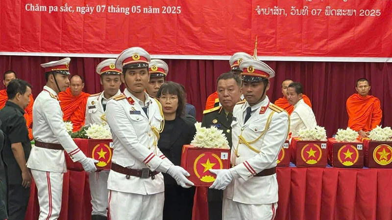 Các đại biểu thực hiện nghi lễ tiễn đưa hài cốt các liệt sĩ về nước. (Ảnh: HẢI TIẾN)