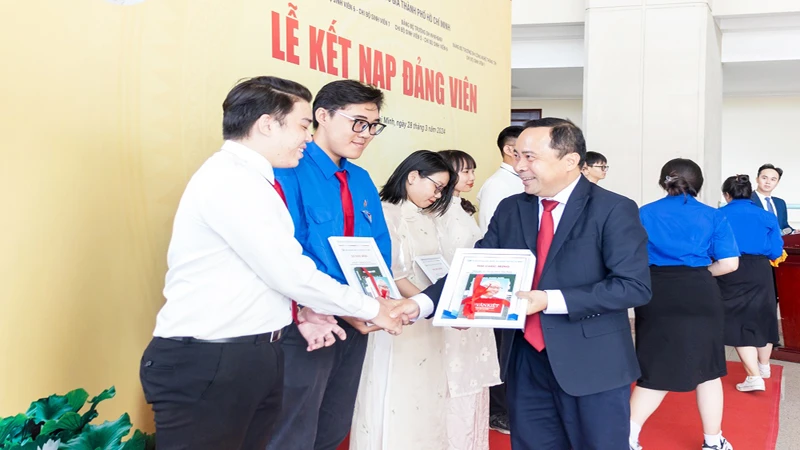 Đồng chí PGS,TS Vũ Hải Quân, Bí thư Đảng ủy, Giám đốc Đại học Quốc gia Thành phố Hồ Chí Minh trao quyết định kết nạp Đảng cho các sinh viên, giảng viên trẻ có thành tích trong nghiên cứu khoa học, công bố… (ảnh: CTV).
