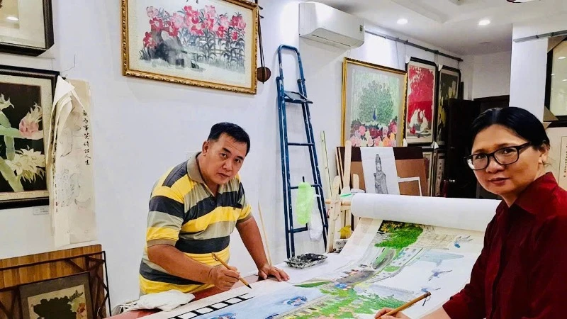 Hai họa sĩ người dân tộc Hoa Trịnh Chiêu Thành và Đào Kim Loan bên tác phẩm của mình.