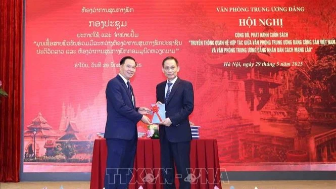 Đồng chí Lê Hoài Trung, Bí thư Trung ương Đảng, Chánh Văn phòng Trung ương Đảng tặng sách cho đồng chí đồng chí Thongsalith Mangnomek, Bí thư Trung ương Đảng, Chánh Văn phòng Trung ương Đảng Nhân dân Cách mạng Lào. (Ảnh: TTXVN) 