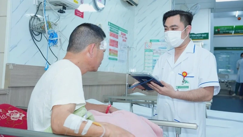 Nhân viên y tế Bệnh viện Bạch Mai sử dụng bệnh án điện tử trong quá trình thăm khám cho bệnh nhân.
