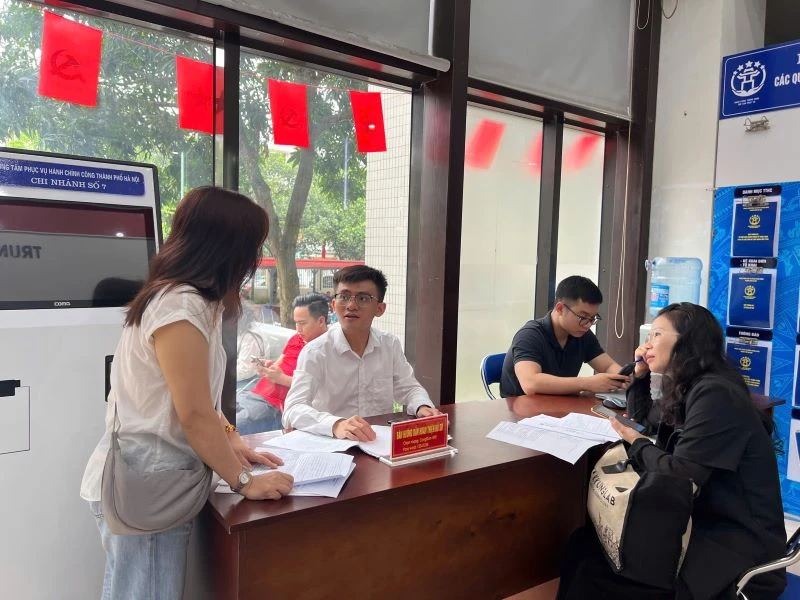 Cán bộ Trung tâm Phục vụ hành chính công - Chi nhánh số 7 hướng dẫn người dân hoàn thiện hồ sơ trước khi vào cửa tiếp nhận.