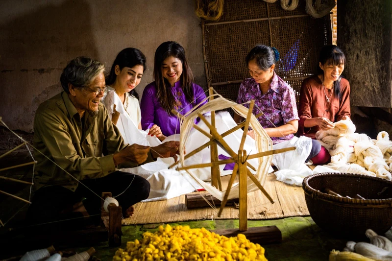 Du khách quốc tế đến làng đũi Nam Cao trải nghiệm quay tơ dệt đũi. Ảnh | Hanhsilk