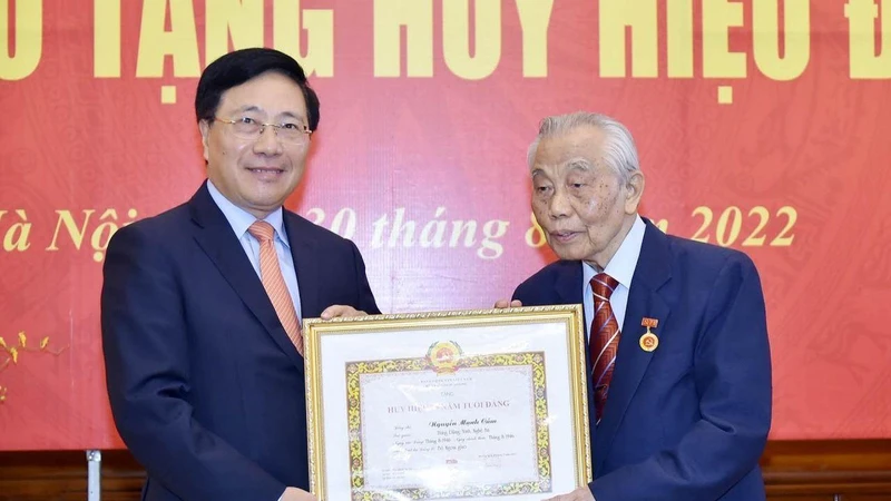 Phó Thủ tướng Thường trực Chính phủ Phạm Bình Minh trao tặng huy hiệu 75 năm tuổi Đảng tặng đồng chí Nguyễn Mạnh Cầm. (Ảnh: baoquocte.vn)