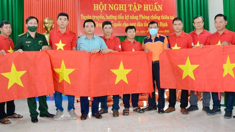 Đại diện báo Người Lao Động, Chi Cục Thủy sản tỉnh Nam Định, Bộ Chỉ huy Bộ đội Biên phòng tỉnh và Trung tâm phối hợp tìm kiếm cứu nạn hàng hải Việt Nam khu vực I trao cờ cho các ngư dân.