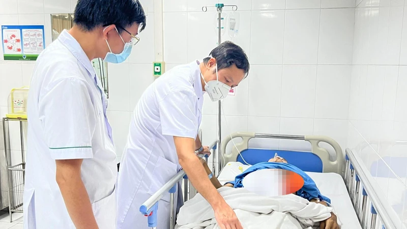 Bác sĩ thăm khám cho người bệnh sau phẫu thuật. 