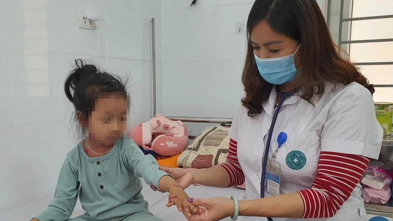 Bác sĩ khám cho bệnh nhi mắc thủy đậu đang nằm viện điều trị. 