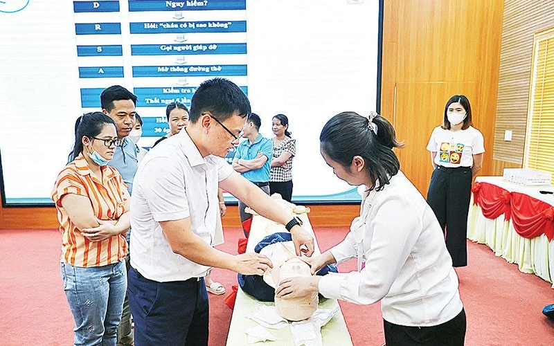 Bác sĩ của Bệnh viện Nhi Trung ương hướng dẫn thực hành sơ cấp cứu khi gặp tai nạn thương tích cho các học viên. (Ảnh: PHƯƠNG THANH)