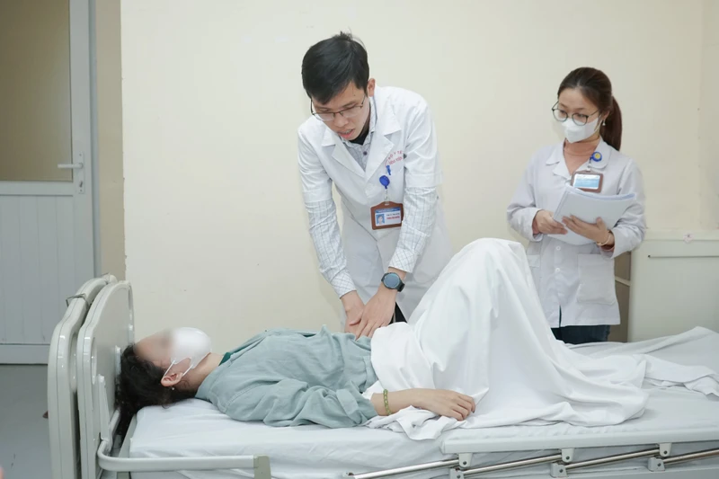 Bác sĩ khám lại cho người bệnh sau can thiệp.